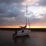 The sun setting over a Seahawk 17 on its mooring at East Quay, Wells-next-the-Sea, North Norfolk