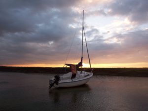 The sun setting over a Seahawk 17 on its mooring at East Quay, Wells-next-the-Sea, North Norfolk