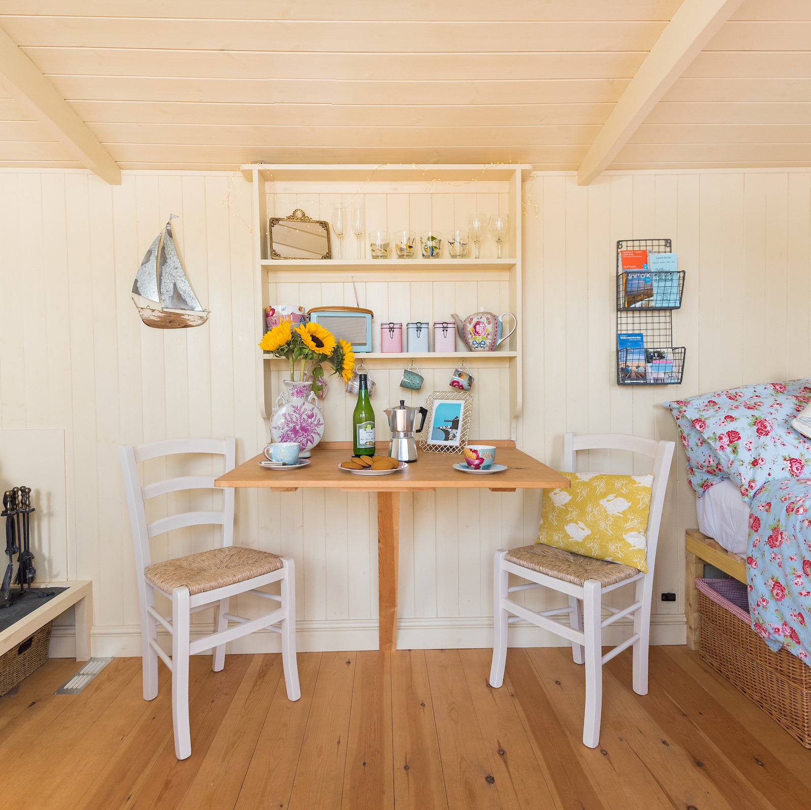 Dining table and chairs below the pretty dresser in Hut-next-the-Sea, the only self-catering Shepherd's Hut accommodation in Wells-next-the-Sea, North Norfolk.